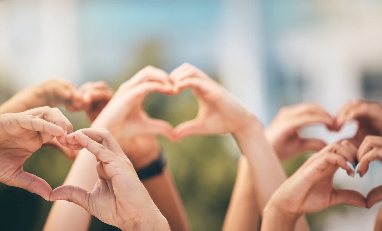 women making heart shapes with their hands