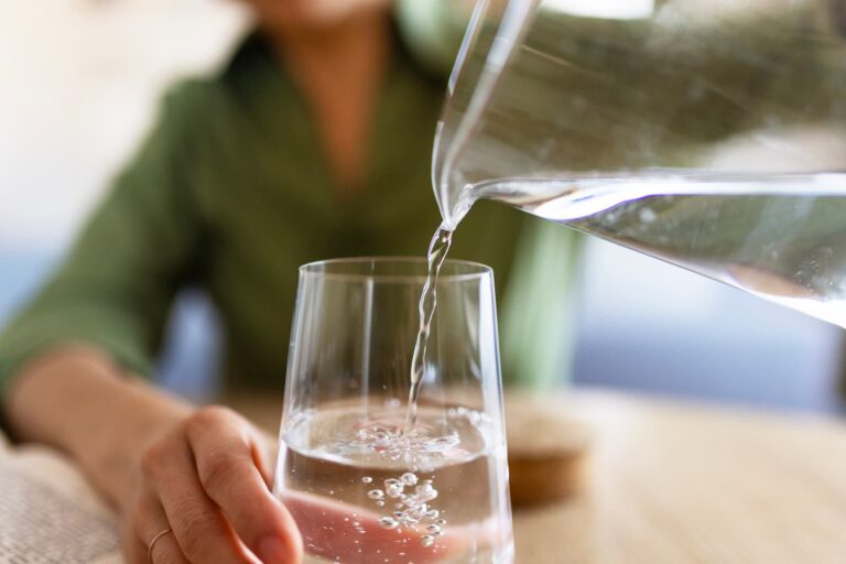 lady pours water into glass