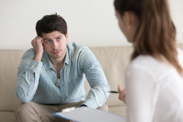 Male patient talking to female doctor about andropause